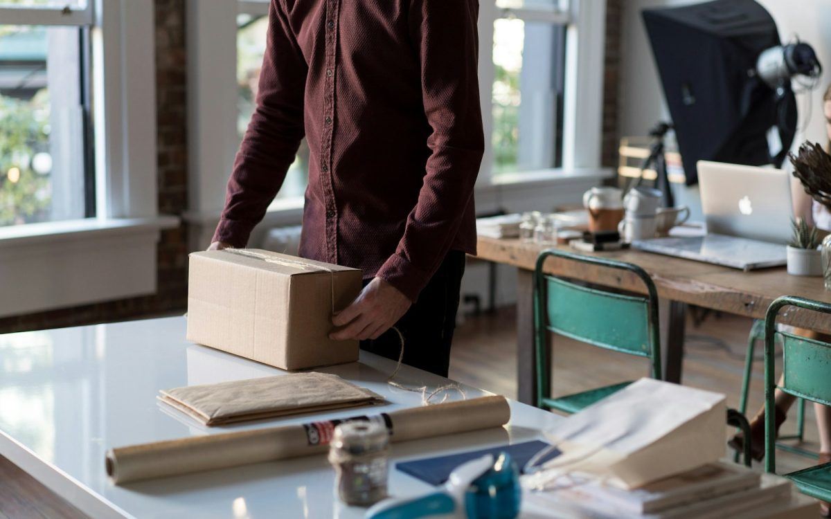 person holding cardboard box on table